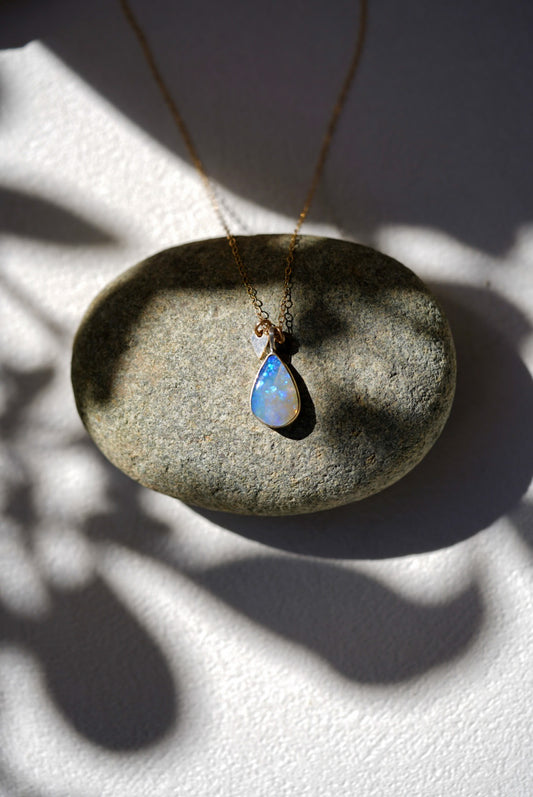 Opal necklace on a stone surface with soft lighting