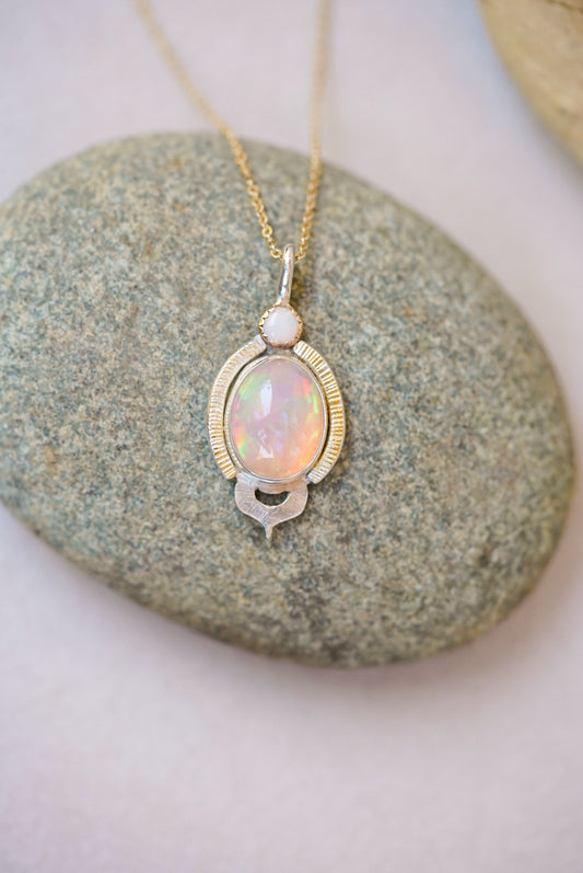 Opal pendant necklace on a stone surface