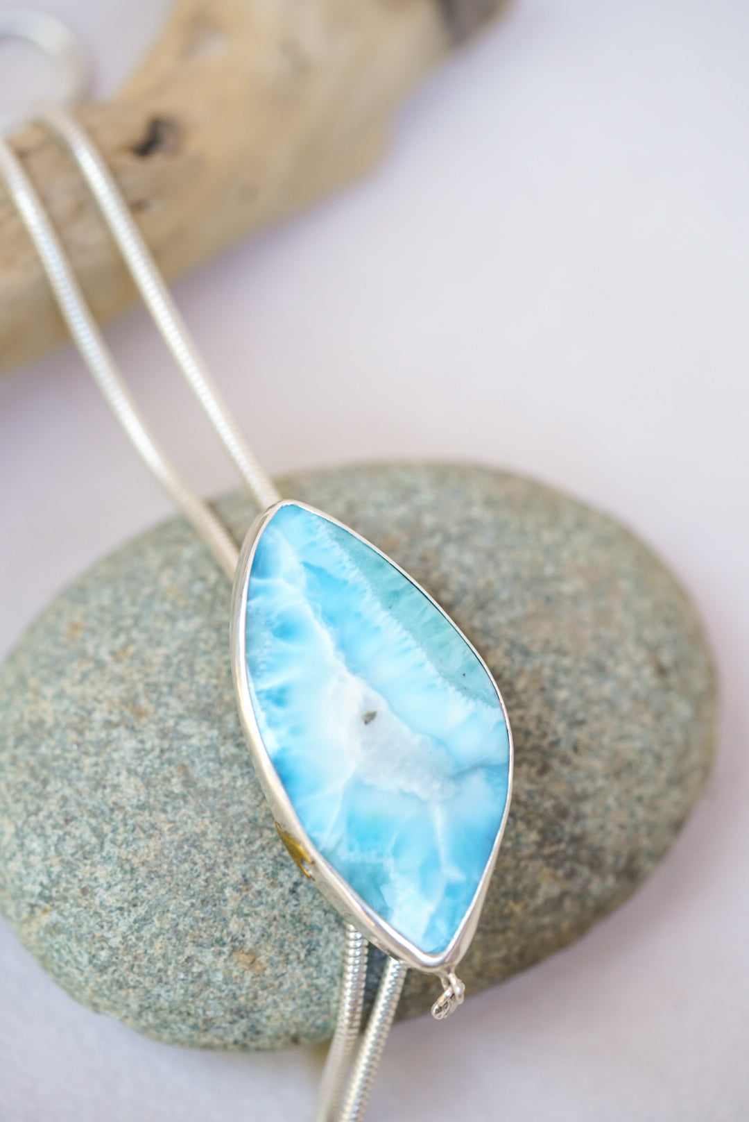 Large blue stone bolo necklace on top of a river rock