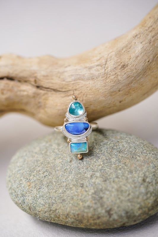 statement ring with blue stones on top of a river rock