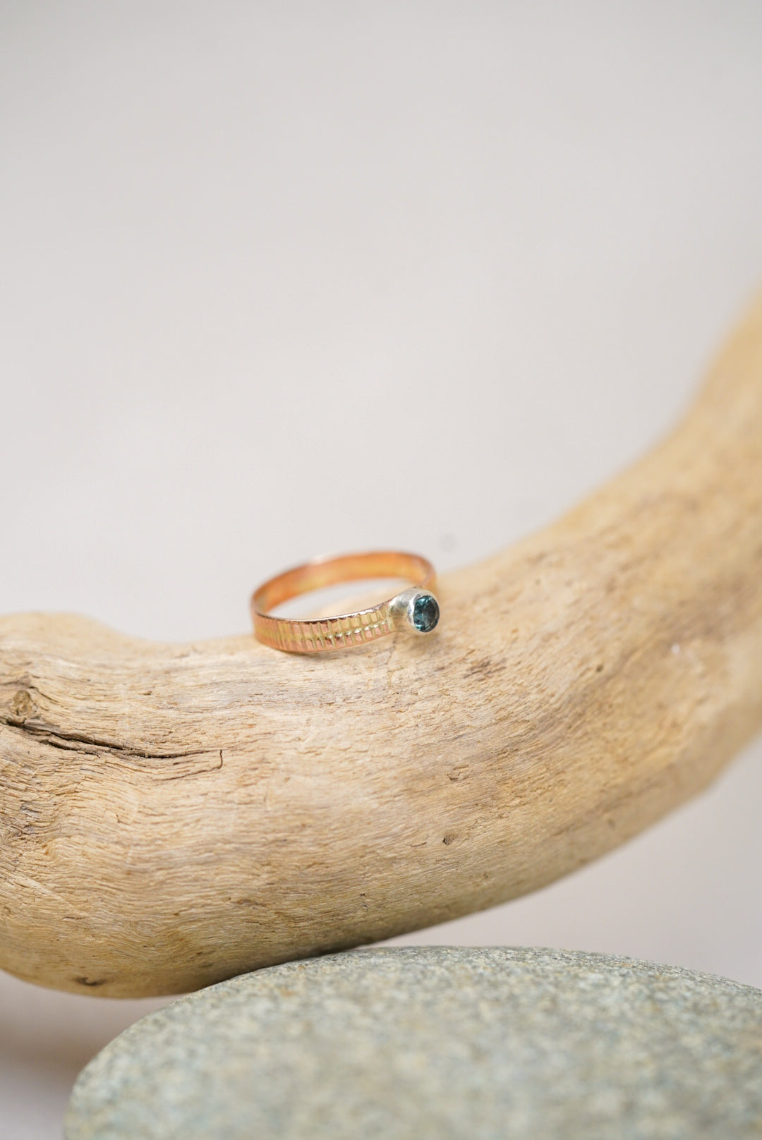 Montana sapphire gold ring on a piece of driftwood