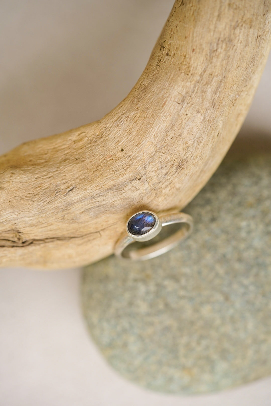 labradorite silver ring against a piece of driftwood