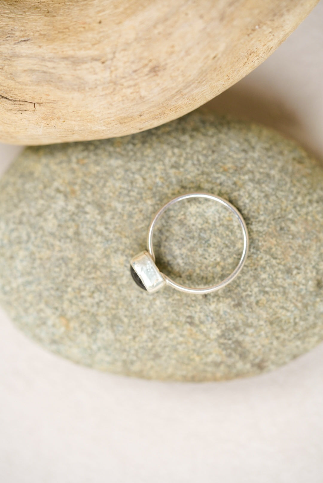 labradorite silver ring on a rock