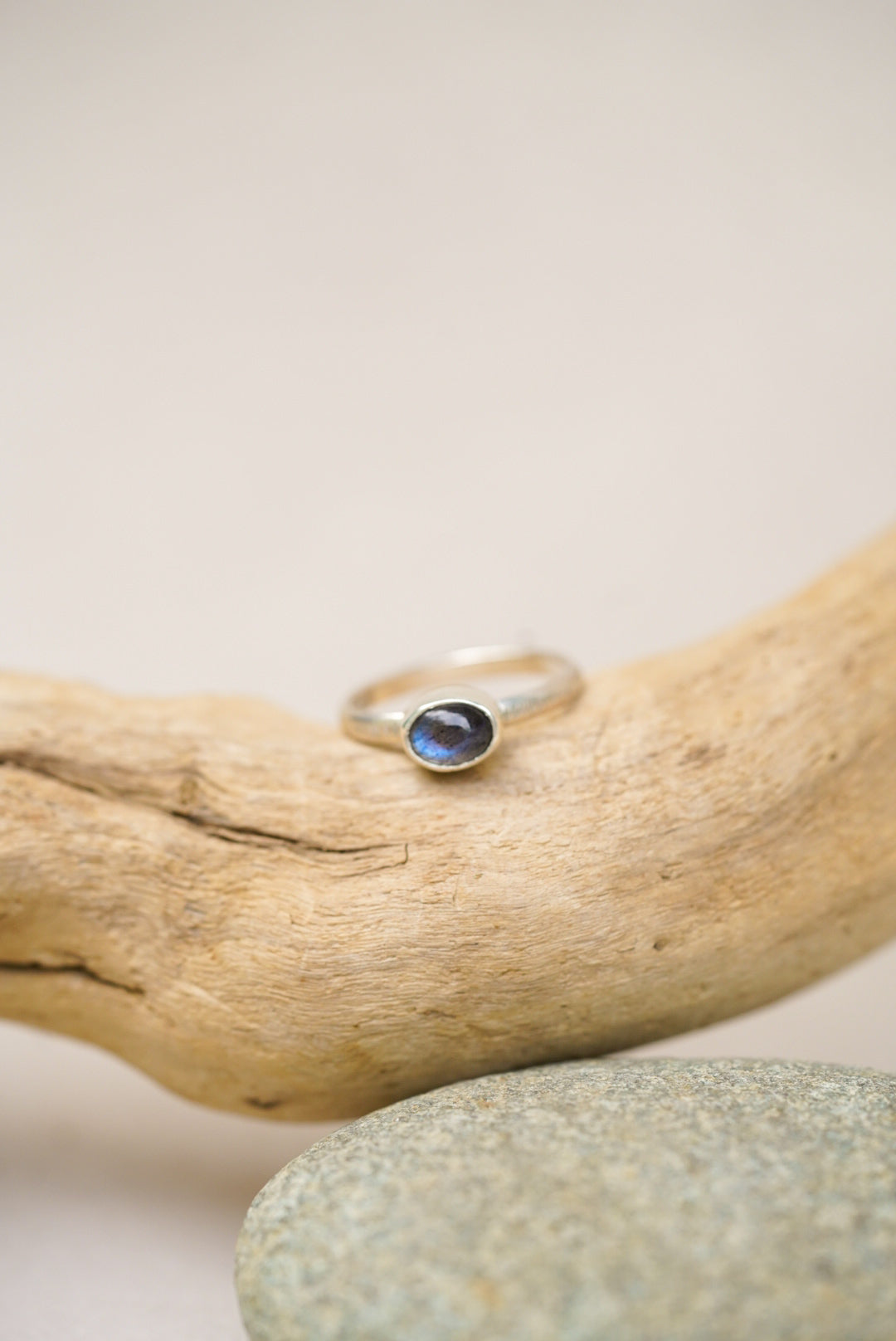 labradorite silver ring against a piece of driftwood