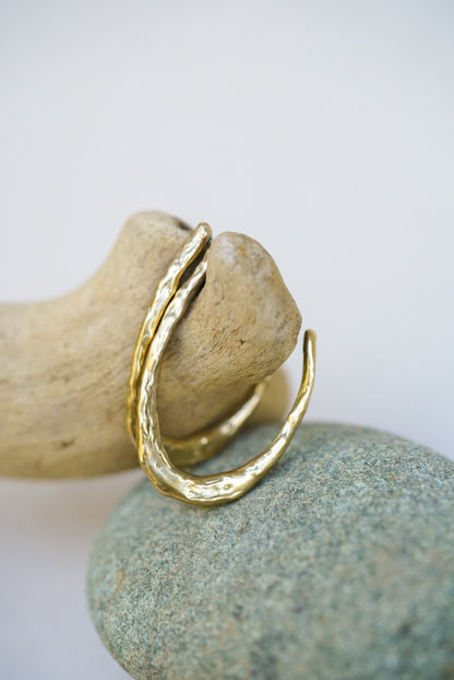 Gold earrings  on a rock with a white background