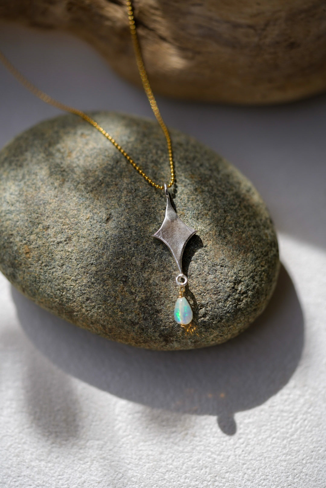 Necklace with a pendant and opal on a stone surface
