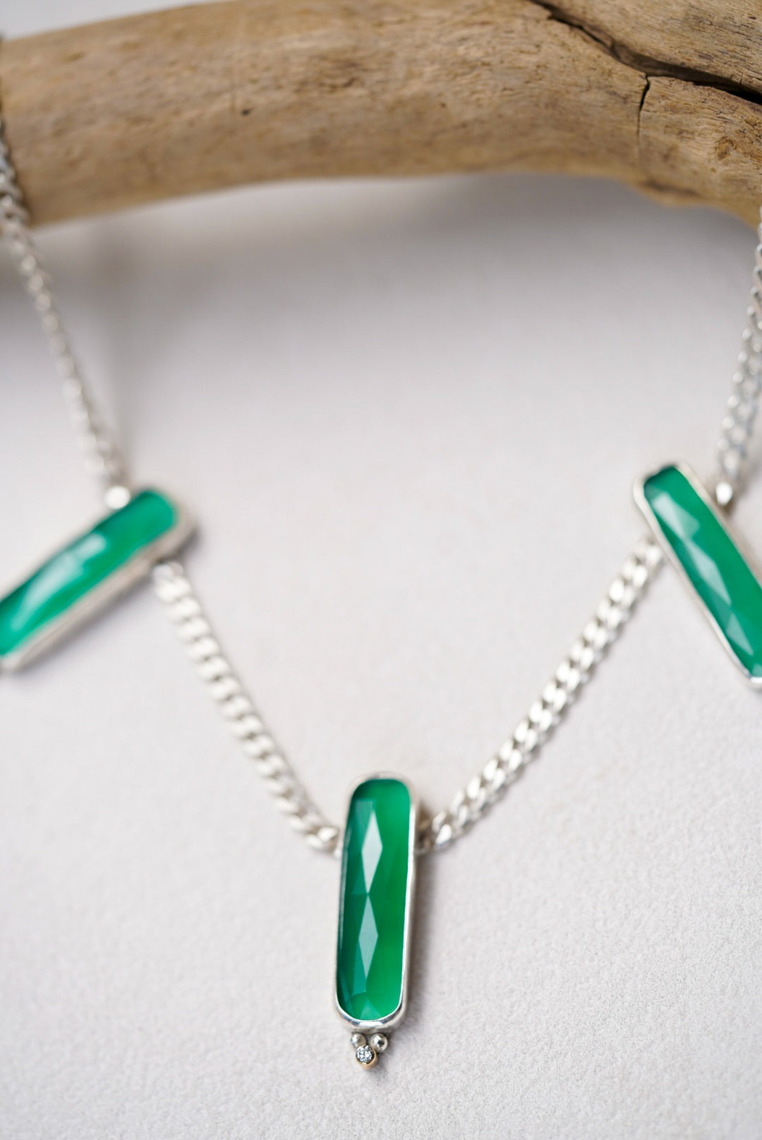 Necklace with green pendants on a white background
