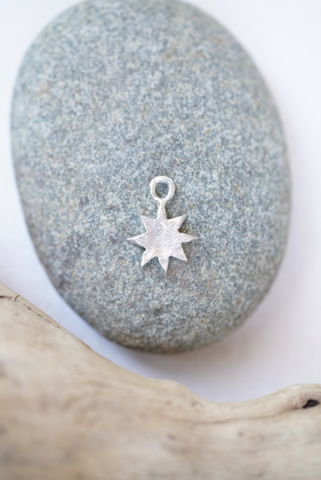 star charm in silver on a rock