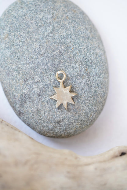 star charm in bronze on a rock
