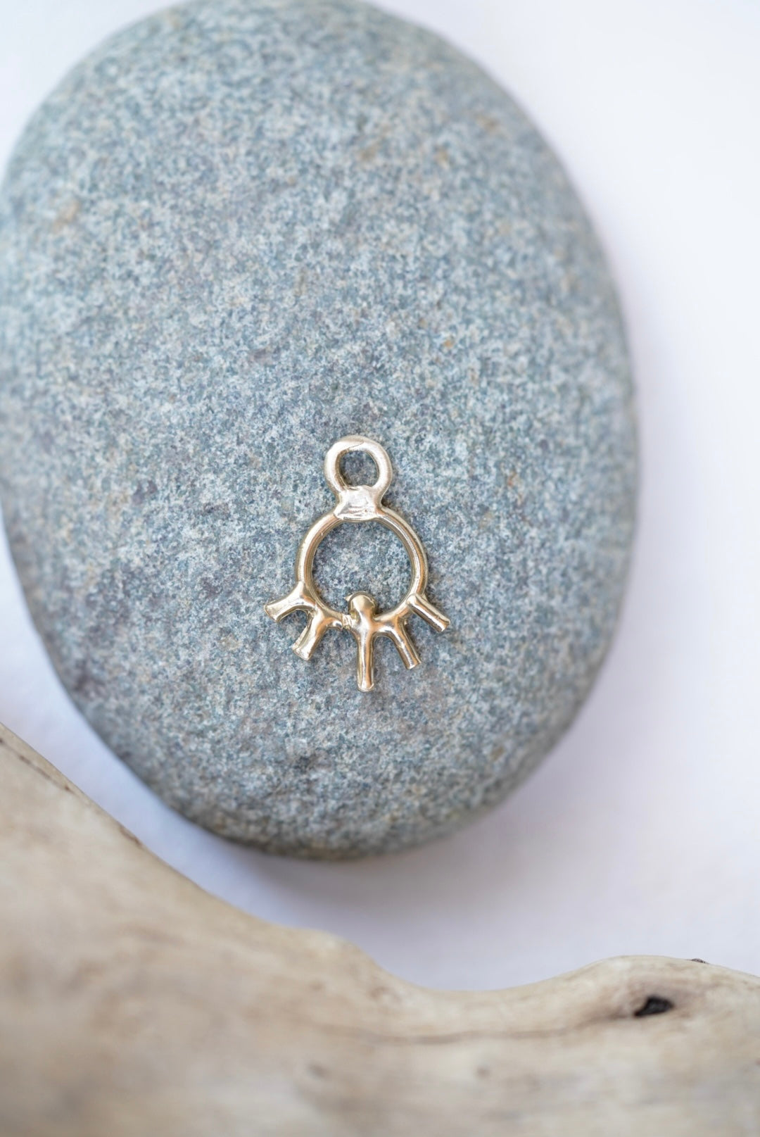sun charm in bronze on a rock