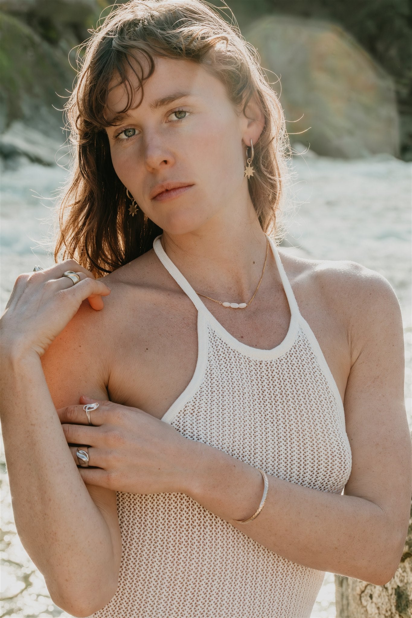 Woman wearing a white sleeveless top on a river, wearing jewelry